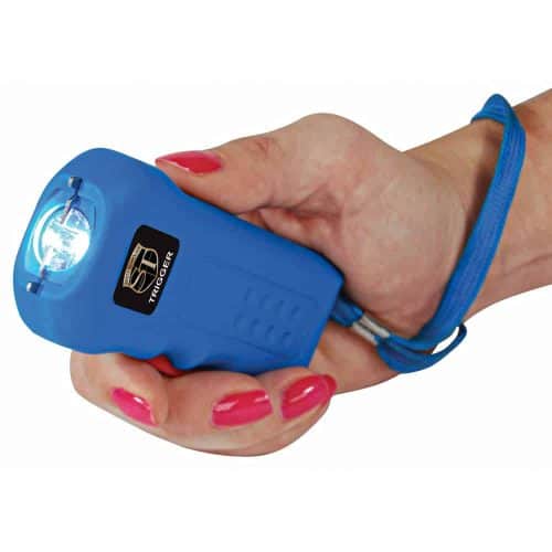 Person holding a blue stun gun with safety strap, ready for self-defense use.
