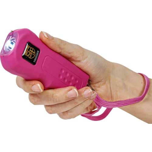 Pink handheld stun gun with wrist strap, designed for personal self-defense.