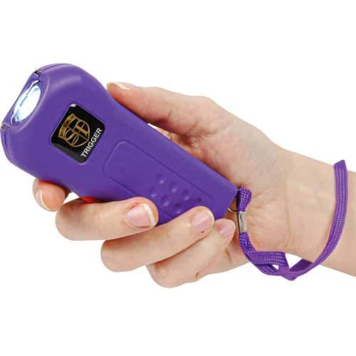 Person holding a purple flashlight; self-defense tool with wrist strap in hand.
