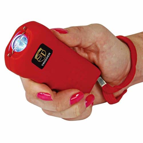 Red stun gun in a hand, showing activation with a bright electric arc for self-defense and personal safety.