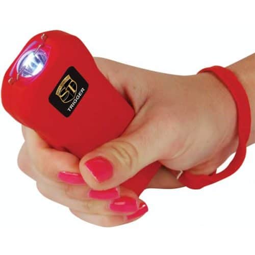 Hand holding a red stun gun with safety band, showing activated electric sparks for personal protection.