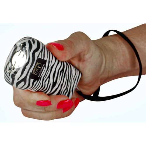 Zebra print stun gun held in hand with pink nails, featuring a safety strap for easy personal protection.